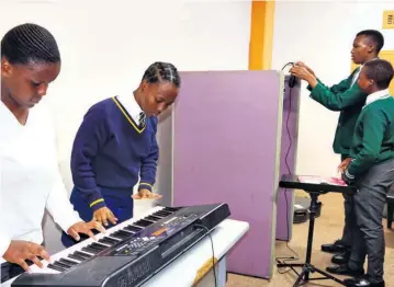  ?? ?? Sithabile Mbatha and Senamile Skhosana test out the keyboard in the music room, with Mangaliso and Zonqoba Ngwenya getting the recording headphones ready in the background
