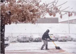  ?? EDDIE MOORE/JOURNAL ?? Gino Rinaldi, director of the Mary Esther Gonzales Senior Center in Santa Fe, clears snow from the building entrance last week. Thanksgivi­ng will be cold, snowy and windy across much of New Mexico.