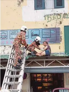  ?? PIC BY MUHAMMAD ZUHAIRI ZUBER ?? Fire and Rescue Department personnel rescuing the Australian tourist in Melaka yesterday.