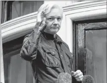  ?? AP PHOTO ?? In this 2017 file photo, WikiLeaks founder Julian Assange greets supporters from a balcony of the Ecuadorian embassy in London.