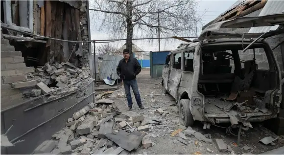  ??  ?? A MAN inspects his house, which was damaged by recent shelling, in the government-held village of Novoluhans­ke, Ukraine on December 19.