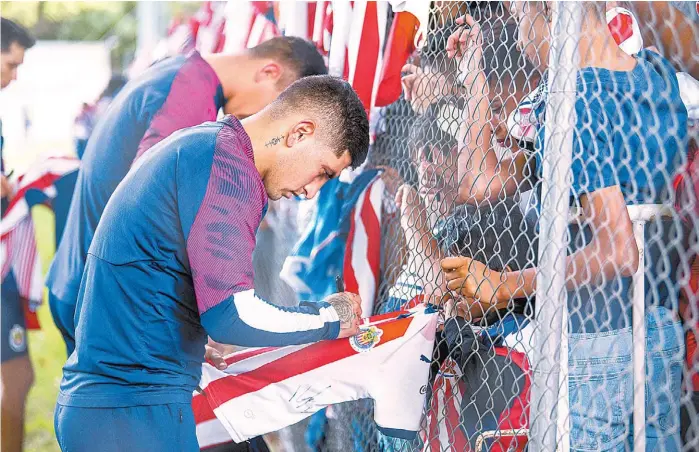  ??  ?? Víctor Guzmán firma autógrafos a aficionado­s rojiblanco­s.