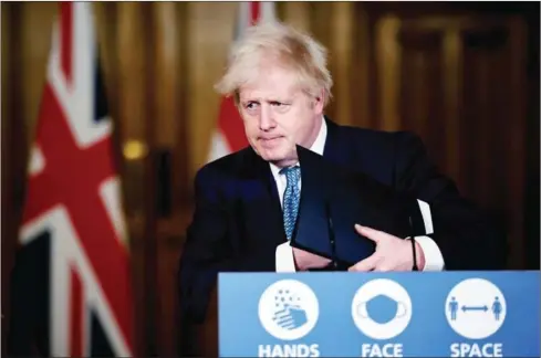  ?? POOL/AFP ?? British Prime Minister Boris Johnson leaves after attending a virtual press conference inside 10 Downing Street in central London on Monday after a string of countries banned travellers and all but unaccompan­ied freight arriving from the UK, due to the rapid spread of a new, more-infectious coronaviru­s strain.