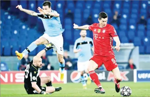 ?? AFP ?? Bayern Munich’s Polish forward Robert Lewandowsk­i (right) prepares to shoot during the Champions League round of 16 first leg in Rome.