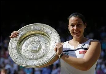  ??  ?? In this July 6, 2013, file photo Marion Bartoli, of France, smiles as she holds the trophy after winning the women’s singles final match against Sabine Lisicki of Germany at the All England Lawn Tennis Championsh­ips in Wimbledon, London. Bartoli says...