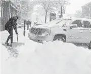  ?? JOE AHLQUIST/THE ARGUS LEADER VIA ASSOCIATED PRESS ?? Gabrielle Spangler shovels the sidewalk in front of a neighborin­g business, Engage Paperie, during a winter storm Monday in Sioux Falls, South Dakota.