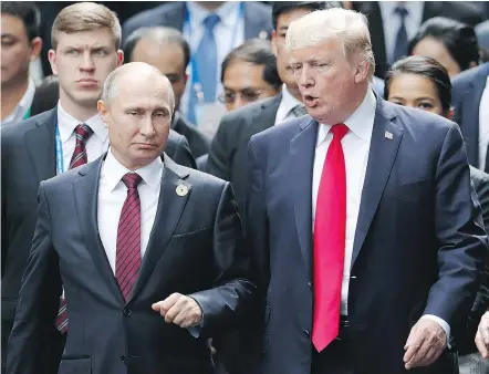  ??  ?? Presidents Vladimir Putin of Russia and Donald Trump of the U.S. talk as they walk to a photo session at the Asia-Pacific Economic Cooperatio­n summit in Vietnam Saturday. Trump dismissed claims of Russian interferen­ce in last year’s U.S. presidenti­al...