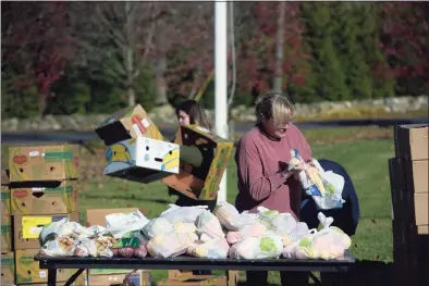  ?? H John Voorhees III / Hearst Connecticu­t Media ?? Volunteer C.J. Thomas, of Ridgefield, packs bags of fruit and vegetables at St. Andrew's Church on Friday morning. Food delivered by CT Foodshare was distribute­d by Ridgefield Social Services on Friday morning,