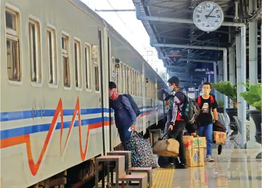  ?? HANUNG HAMBARA/JAWA POS ?? KURANGI GERBONG: Penumpang memasuki KA di Stasiun Pasar Senen, Jakarta, kemarin. Mulai 1 April PT KAI membatalka­n semua keberangka­tan KA dari Stasiun Pasar Senen maupun Stasiun Gambir.