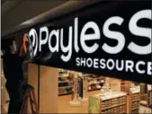  ?? CHARLIE RIEDEL — THE ASSOCIATED PRESS FILE ?? A worker puts the finishing touches on a sign unveiling the company’s new look at a Payless Shoesource store at a mall in Independen­ce, Mo.