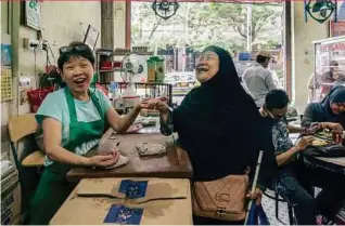  ??  ?? Lim Boi Eng and Munah Abdullah, unlikely friends in the heart of Kuala Lumpur.