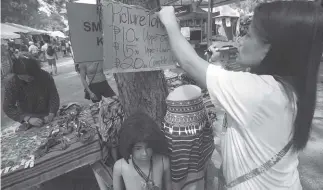  ?? Photo by Jean Nicole Cortes ?? ADDED ATTRACTION. Aside from trinkets and souvenir items, vendors at the market encounter of the Baguio Blooms offer picture taking using Cordillera traditiona­l clothes for P10 – 20.