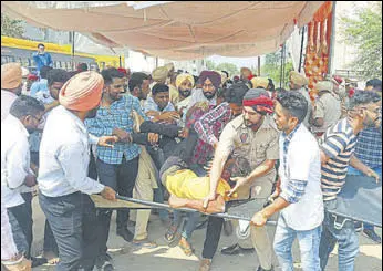  ?? HT PHOTO ?? Police trying to shift one of the two unemployed ETT teachers, who have been on hunger strike for the past seven days, in Sangrur on Wednesday as fellow protesters resist the move.