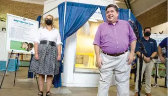  ??  ?? Gov. J.B. Pritzker and first lady M.K. Pritzker unveil the 2021 Butter Cow Wednesday at the Illinois State Fairground­s.