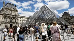  ?? PHOTO: REUTERS ?? Tourists queue in the sun to visit the Louvre Museum in Paris last month.