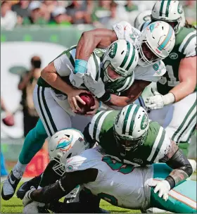  ?? JULIO CORTEZ/AP PHOTO ?? Miami Dolphins defensive end Robert Quinn (94) sacks New York Jets quarterbac­k Sam Darnold (14) during the first half of Sunday’s game at East Rutherford, N.J.