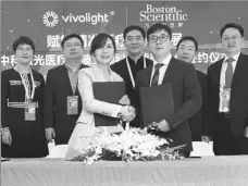  ?? ZHANG YUWEI / XINHUA ?? Top: The stall of Novo Nordisk at the third China Internatio­nal Import Expo in Shanghai. Above: Representa­tives of Boston Scientific and Vivolight sign a strategic cooperatio­n agreement during the third CIIE in November.