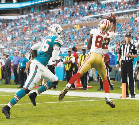  ?? Wilfredo Lee / Associated Press ?? Torrey Smith grabs a Colin Kaepernick pass for a touchdown in the fourth quarter as the 49ers staged a comeback in Miami.