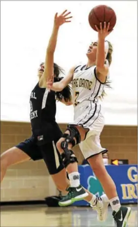  ?? ROBERT J. GURECKI — DAILY TIMES ?? Notre Dame’s Caitlyn Clark, right, gets past Episcopal Academy’s Olivia Dirks for a layup during the Irish’s 41-33 victory in the showdown between Inter-Ac League rivals Tuesday.