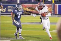  ?? TOM R. SMEDES/ASSOCIATED PRESS ?? UNM wide receiver Jordan Kress (9) straight-arms Nevada’s Tyson Williams (6) during the second half of the Lobos’ 21-10 loss to the Wolf Pack on Saturday night.