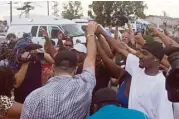  ?? 10News.com via Associated Press ?? People clasp hands in protest Thursday near where police shot and wounded a man in the San Diego suburb of El Cajon, Calif.