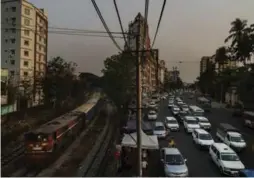  ??  ?? A train passes idled road traffic near the downton Kyeemyinda­ing station.