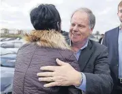  ?? [AP PHOTO] ?? U.S. Senator-elect Doug Jones embraces a supporter outside Bethel Baptist Church on Tuesday in Birmingham, Ala.