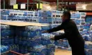  ??  ?? A customer grabs a case of drinking water at a Costco store on 14 March 2020 in Novato, California. Photograph: Justin Sullivan/Getty Images