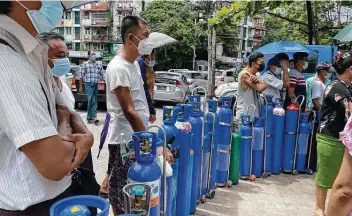  ?? Associated Press ?? People queue up with oxygen tanks Sunday at a refill station in Pazundaung township in Yangon, Myanmar.