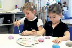  ?? LAURA BARTON/POSTMEDIA NEWS ?? Evelyn Gunton, 5, and Ava Caporicci, 4, two kindergart­en students at St. Alexander Catholic Elementary School in Pelham, paint rocks in their classroom. The girls, along with their class, painted the rocks, then wrote positive words or drew positive...