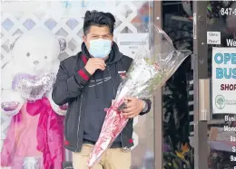  ?? NAM Y. HUH/AP ?? A man carries his purchase out of a flower shop Saturday in Morton Grove, Illinois. Many families that were separated by lockdowns imposed because of the pandemic last year made plans for long-awaited reunions Sunday for Mother’s Day.