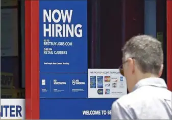  ?? ALAN DIAZ — THE ASSOCIATED PRESS ?? A “Now Hiring” sign welcomes a customer entering a Best Buy store in Hialeah, Fla. U.S. employers added a robust 222,000 jobs in June, the most in four months, a reassuring sign that businesses may be confident enough to keep hiring despite a...