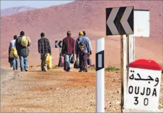 ?? REMY DE LA MAUVINIERE/ AP ?? A group of illegal immigrants from Senegal make their way to Oujda, Morocco, last week. The migrants said they were abandoned in the desert by Moroccan police and forced to fend for themselves.