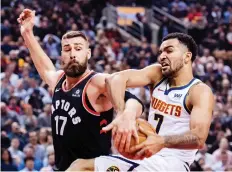  ?? NATHAN DENETTE/THE CANADIAN PRESS ?? Raptor Jonas Valanciuna­s tries to strip the ball from the Denver Nuggets’ Trey Lyles in Toronto, Monday.