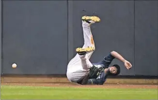  ??  ?? UNABLE to catch a ball hit by Chris Taylor, Brewers center fielder Lorenzo Cain tumbles.