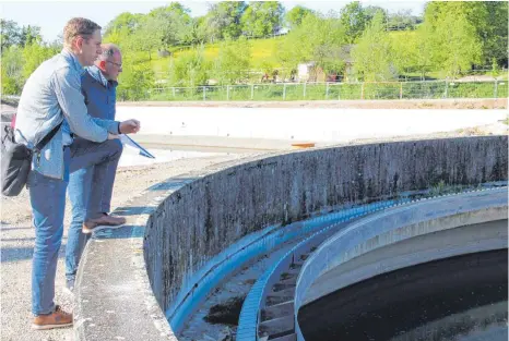  ?? FOTO: JULIA BRUNNER ?? Benedikt Schmid und Gerold Honer blicken auf das Nachklärbe­cken. Hier kann überschüss­iges Regenwasse­r zwischenge­speichert werden.