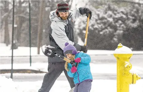  ?? RICKKINTZE­L/THE MORNING CALL ?? Olivia Lovitto, 3, gives a helping hand to her father, Michael, as they clear the sidewalk of their Allentown home Feb. 20, 2019. While no one says snow and cold spells are things of the past, winters have warmed considerab­ly since 1970 in the Northeast.