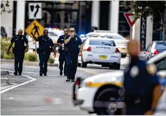  ?? LAURA HEALD / ASSOCIATED PRESS ?? Police gather in Jacksonvil­le, Fla., on Sunday after a gunman opened fire at the GLHF Game Bar during a video game tournament being livestream­ed over the internet.