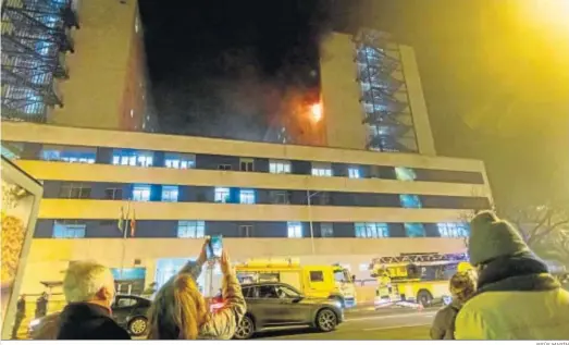  ?? JESÚS MARÍN ?? Una mujer graba con su móvil el incendio provocado ayer en el hospital Puerta del Mar de Cádiz.