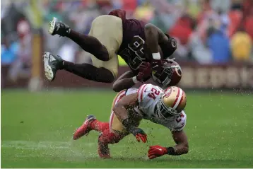  ?? Julio Cortez/Associated Press ?? ■ Washington Redskins tight end Jeremy Sprinkle, top, flips over San Francisco 49ers defensive back K’Waun Williams as he rushes the ball Sunday in Landover, Md.
