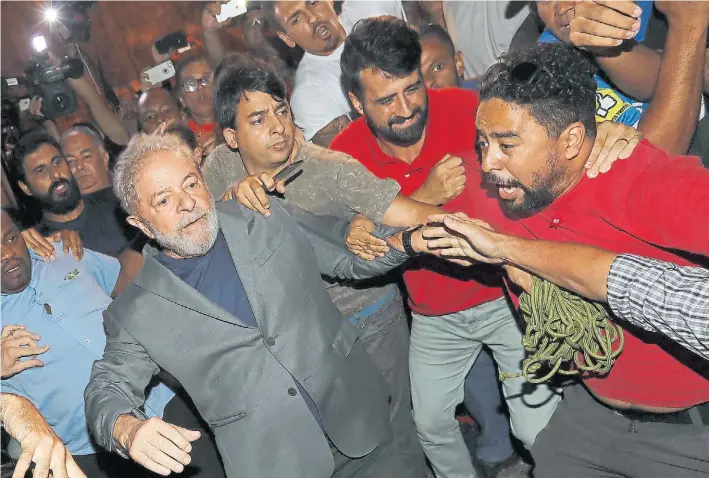  ?? EFE ?? Tensión. Partidario­s de Lula le traban el camino en el momento que busca dejar la sede del sindicato metalúrgic­o para entregarse a la justicia y partir a Curibia.