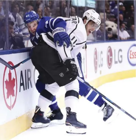  ?? RICHARD LAUTENS/TORONTO STAR ?? Leafs forward Leo Komarov discovers there’s not a lot of space between the boards and the broad side of Kings centre Anze Kopitar. The Leafs, with big contributi­ons from Frederik Andersen and Mitch Marner, beat the Kings 3-2 to hand L.A. its first...