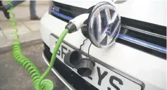  ?? — Reuters photo ?? An electric Volkswagen car is plugged into a recharging point in central London, Britain Nov 10, 2016.