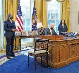  ?? EVAN VUCCI Associated Press ?? PRESIDENT BIDEN signs a bill on small business loans as Vice President Kamala Harris, left, and Cabinet member Isabel Guzman look on in the Oval Office.