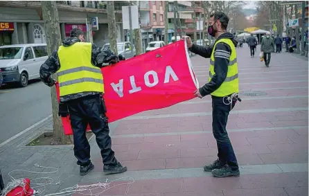  ?? AP ?? Dos operarios retiran un cartel del PSC en una calle de Barcelona, una vez celebradas las elecciones del pasado domingo