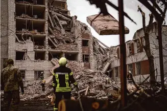  ?? Francisco Seco/Associated Press ?? Firefighte­rs work on a building that was partially destroyed after a Russian bombardmen­t in Chernihiv, Ukraine, on Wednesday.