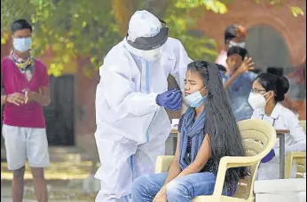  ?? PARVEEN KUMAR/HT ?? A health worker collects a swab sample from a girl at Government Senior Secondary School in Gurugram’s Dundahera village on Friday.