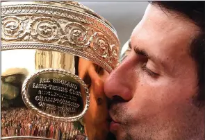  ?? Associated Press ?? Victory kiss: Serbia's Novak Djokovic kisses the trophy during the presentati­on after he defeated Switzerlan­d's Roger Federer during the men's singles final match of the Wimbledon Tennis Championsh­ips in London, Sunday.