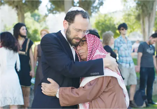  ?? (Sarah Schuman/Flash90) ?? RABBI YAKOV NAGEN of Otniel embraces Haj Ibrahim Ahmad Abu el-Hawa of Jerusalem during an event called The Big Hug, in 2013.