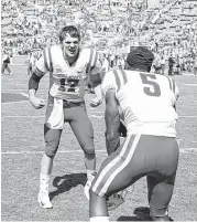  ?? Ian Maule / Tulsa World ?? Iowa State quarterbac­k Kyle Kempt, left, who passed for 343 yards and three touchdowns, celebrates with defensive back Kamari Cotton-Moya after the Cyclones’ upset of No. 3 Oklahoma at Norman, Okla.